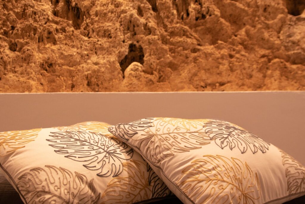 Cama del dormitorio principal con pared de piedra